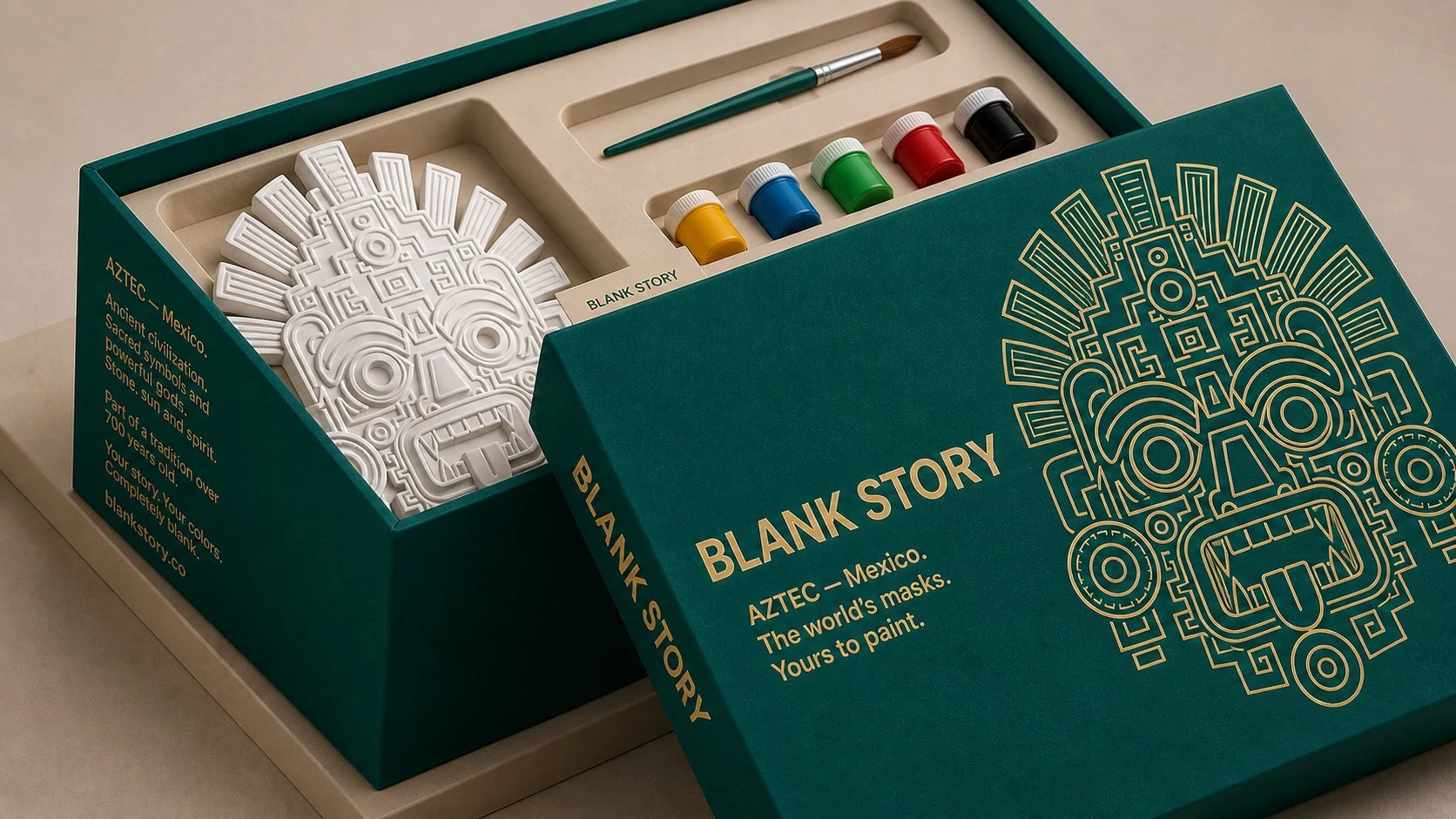 Aztec BLANK Story mask painting kit, teal-green box open showing white plaster Mexica stone mask, paint pots, and brush