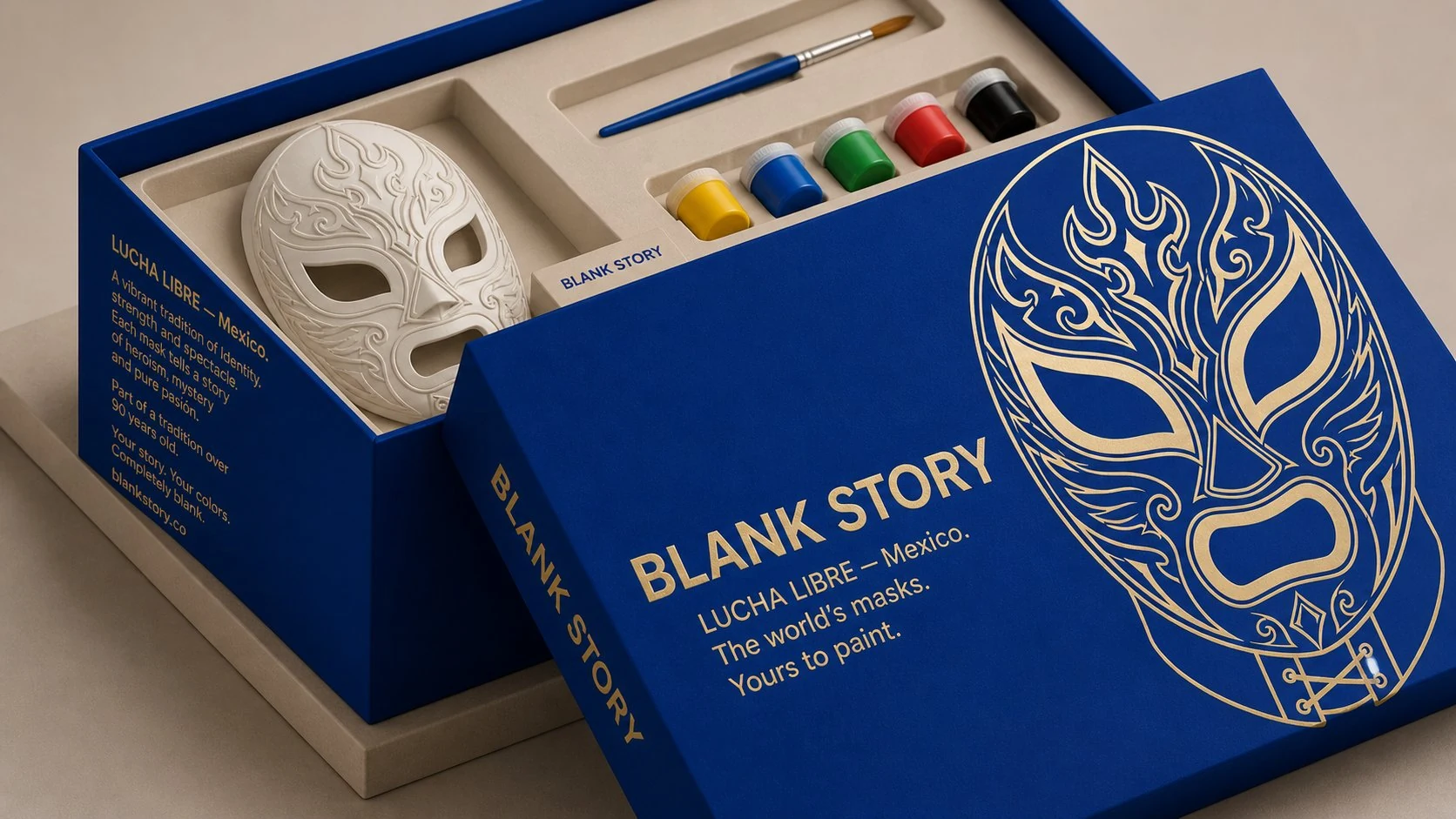 Lucha Libre BLANK Story mask painting kit, cobalt-blue box open showing white plaster luchador mask, paint pots, and brush